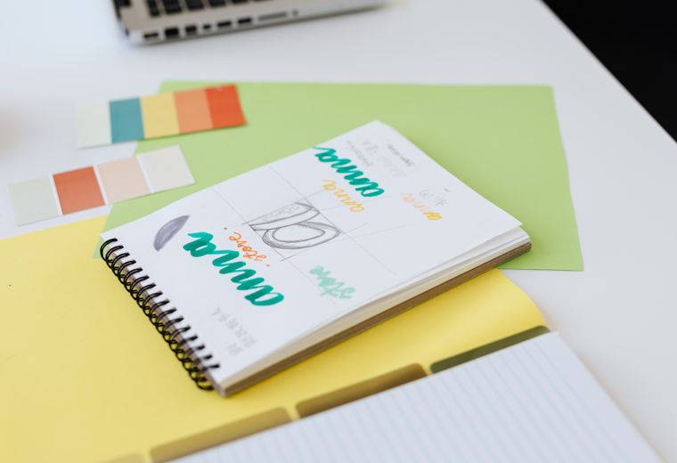 Logo sketches and color swatches in a sketchbook