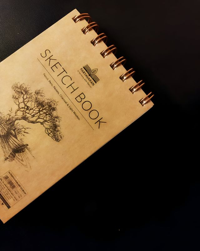 A sketchbook resting on a dark surface