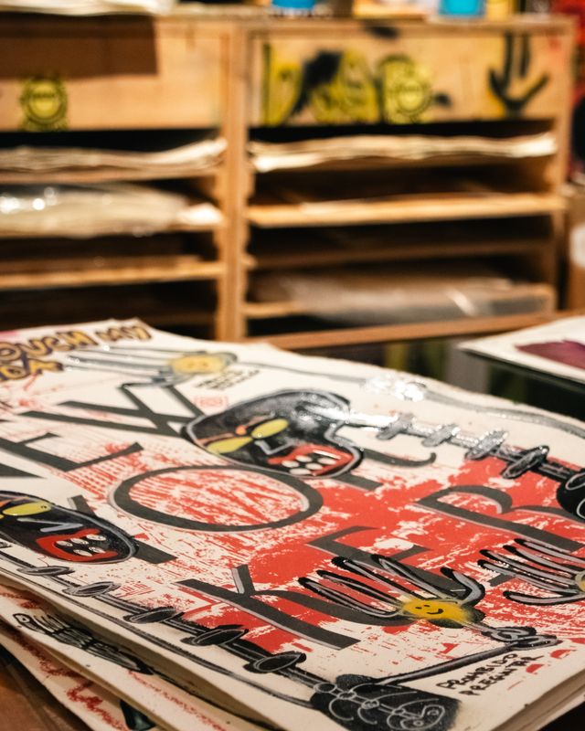 Stack of screen-printed posters in a print studio